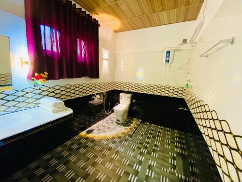 uma casa de banho com um WC e uma cortina vermelha em Rathnapriya Safari Guest Galoya em Ampara