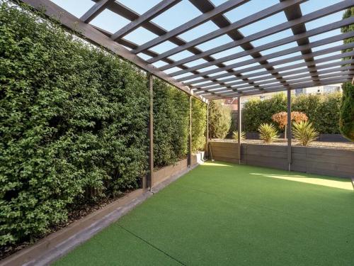 a pergola with a green lawn in a garden at Escape to Coastal Tranquility in Primrose Sands