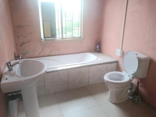 a bathroom with a tub and a toilet and a sink at Lethabo Bed & Breakfast Bizana in Bizana
