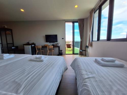 two beds in a room with a view of the ocean at Atom Phuket Hotel in Nai Yang Beach