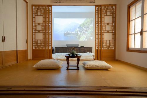 a room with two pillows and a table with a window at Sirakdang Hanok in Seoul