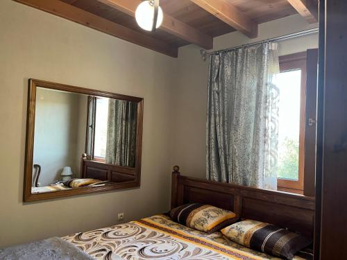 1 dormitorio con cama con espejo y ventana en Жанет en Kalofer