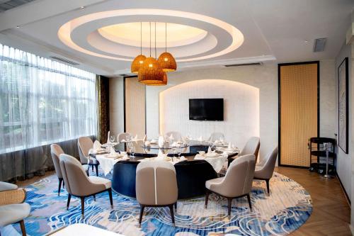 a conference room with a table and chairs and a chandelier at Pullman Haikou in Haikou