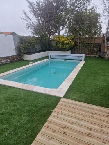 - une piscine dans une cour avec de l'herbe verte dans l'établissement Maison pour 8 avec piscine - Noirmoutier-en-l'Île, à Noirmoutier-en-l'lle