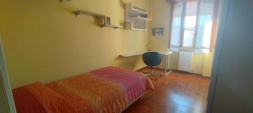 CastellaranoにあるAppartamento a Castellarano Manzoni houseのベッドルーム1室(ベッド1台、デスク、窓付)