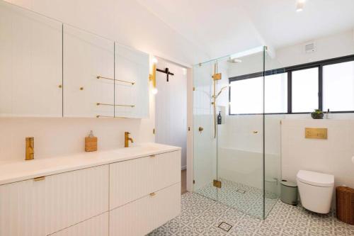 a bathroom with a shower and a sink and a toilet at Beach Retreat Chic: Poolside on the Esplanade in Port Douglas