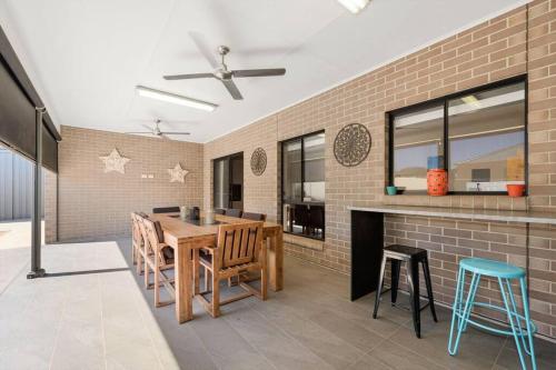 a kitchen with a table and chairs and a brick wall at Calm Waters in Port Moonta
