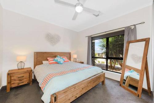 Schlafzimmer mit einem Bett, einem Fenster und einem Spiegel in der Unterkunft Calm Waters in Port Moonta