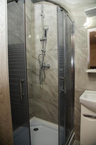 a shower with a glass door in a bathroom at Готель Бережани in Brzezhany