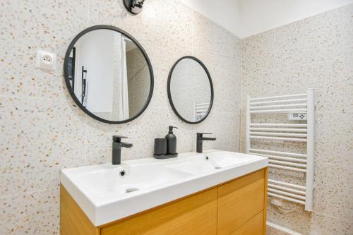 une salle de bain avec un lavabo blanc et deux miroirs dans l'établissement Bel appart 2 ch clim à Vauban proche Vieux-Port, à Marseille
