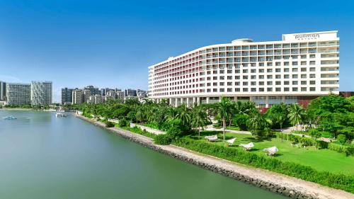 a large building next to a body of water at Pullman Haikou in Haikou
