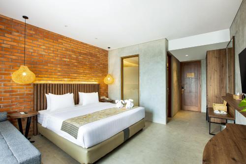 a bedroom with a large bed and a brick wall at Greenhost Boutique Hotel Prawirotaman in Yogyakarta
