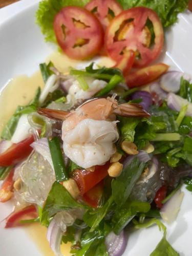 a white plate with a salad with shrimp and vegetables at Thai Smile Bungalows in Ko Lanta