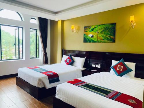 a hotel room with two beds and a window at Sapa Melody Hotel in Sa Pa
