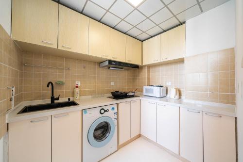 a kitchen with a washing machine and a sink at Shanghai Yi Du B&B - Family Suite 500m to Nanjing West Rd Near People's Square -Credit Cards Accepted in Shanghai