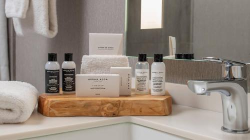 a bathroom counter with bottles of soap and towels at Hotel Paradox, Autograph Collection in Santa Cruz