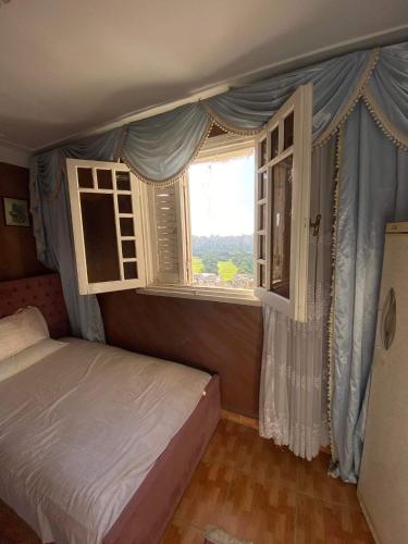 - une chambre avec un lit et une fenêtre dans l'établissement Downtown Apartment, à Alexandrie