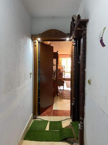 une porte ouverte menant à une chambre dotée d'un tapis vert dans l'établissement Downtown Apartment, à Alexandrie