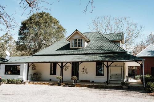 a white house with a green roof at Auld Schoolhouse in Coolangatta