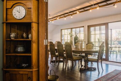 a dining room with a table and a clock at Auld Schoolhouse in Coolangatta