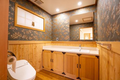 a bathroom with a sink and a toilet and a mirror at Sirakdang Hanok in Seoul