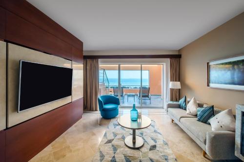 a living room with a couch and a tv at Grand Fiesta Americana Veracruz in Veracruz