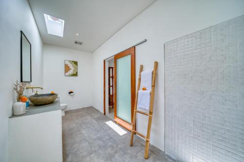 a bathroom with a white brick wall and a ladder at *NEW* Modern 3BD Villa in quiet Perenenan! in Canggu