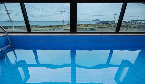 a swimming pool with a view of the ocean at Homechee Poolvilla in Jeju