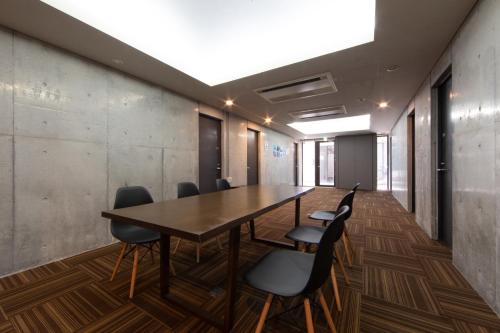 an office meeting room with a wooden table and chairs at HOTEL E-horizon Resort コンドミニアム瀬底 in Motobu