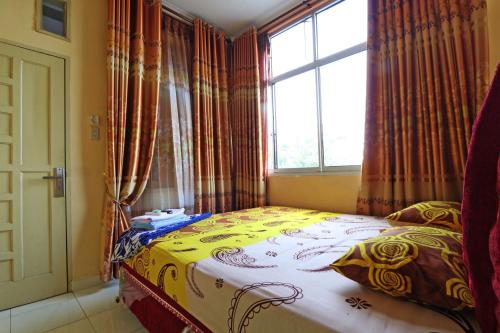 uma cama num quarto com uma janela em Wisma Barokah em Tebingtinggi