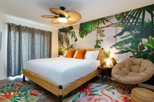 um quarto com uma cama, uma ventoinha e uma cadeira em Flamingo Bay Coastal Oasis: Modern Comforts, Heated Pool w/ BBQ em Tampa