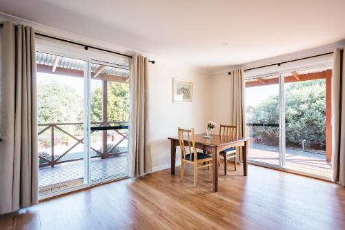 a dining room with a table and large windows at Owen's Hideaway by the BnB Collection in Albany