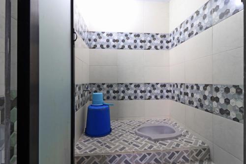 a bathroom with a blue toilet in the corner at Wisma Barokah in Tebingtinggi