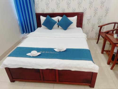 a bedroom with a bed with two hats on it at Anh Tuấn Hotel & Coffee - Pleiku, Gia Lai in Pleiku