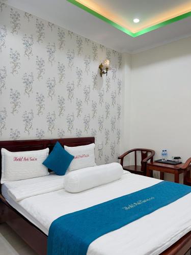 a bedroom with a large bed with a blue blanket at Anh Tuấn Hotel & Coffee - Pleiku, Gia Lai in Pleiku