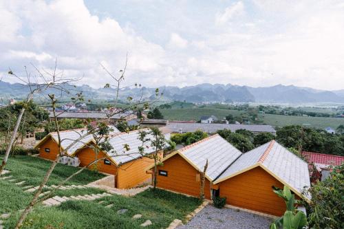 a group of buildings with mountains in the background at Avatar Homestay & Coffee - Mộc Châu in Mộc Châu
