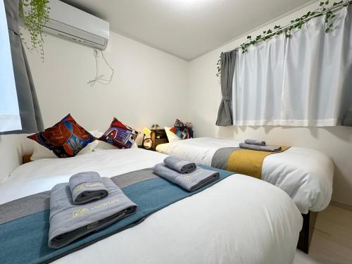 two beds sitting next to each other in a room at nestay villa tokyo sugamo in Tokyo