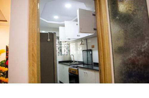uma cozinha com armários brancos e um forno com placa de fogão em Housesixapartment em Loburo