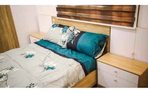 um pequeno quarto com uma cama com lençóis azuis em Housesixapartment em Loburo