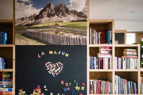 a book shelf with a heart painted on a wall at La Majun Fornellahof in Antermoia