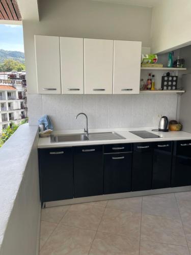 a kitchen with black and white cabinets and a sink at Phuket Palace Condumminium in Patong Beach