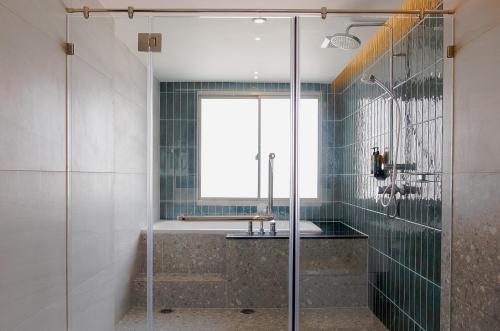 a bathroom with a glass shower and a sink at Buri Sriphu Hotel in Hat Yai