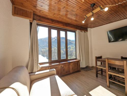 a bedroom with a bed and a large window at Mansarda con vista panoramica Limone Piemonte in Limone Piemonte