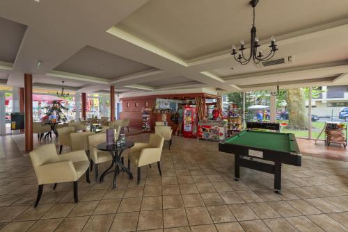 a restaurant with a pool table and chairs at Hotel Lido in Siófok