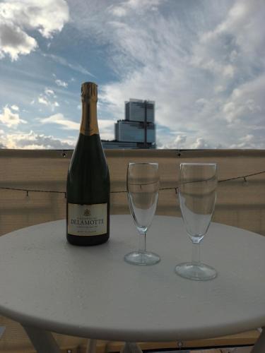 - une bouteille de champagne et 2 verres à vin sur une table dans l'établissement PARIS Balcony TOP FLOOR Room, à Paris