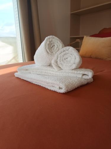 une pile de serviettes posée sur un lit dans l'établissement PARIS Balcony TOP FLOOR Room, à Paris