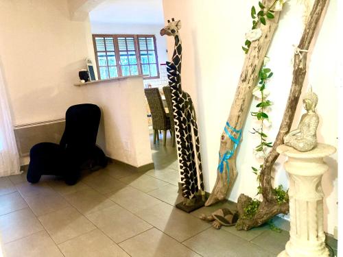 a room with a giraffe and some statues on the wall at Villa 110m2, 7 pers, Jacuzzi , 3 chambres, terrain clos et arboré 2500m2 in Trèbes