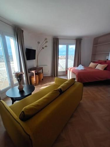 - un salon avec un canapé jaune et un lit dans l'établissement PARIS Balcony TOP FLOOR Room, à Paris