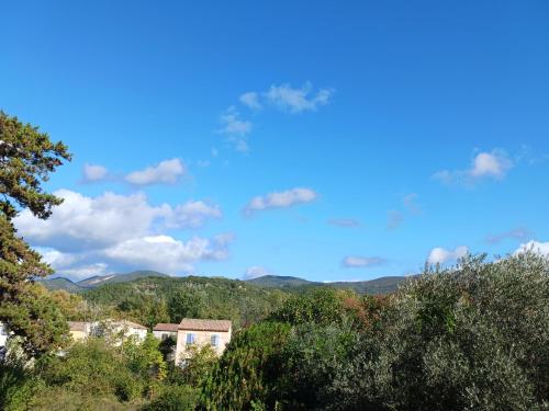 a view of trees and mountains with a blue sky at Hotel Du Lac in Château-Arnoux-Saint-Auban