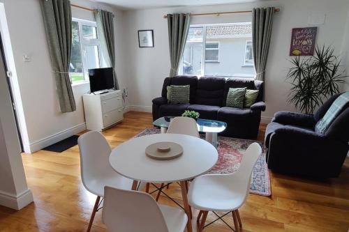 a living room with a white table and chairs at Sweethaven Chalet in Killarone